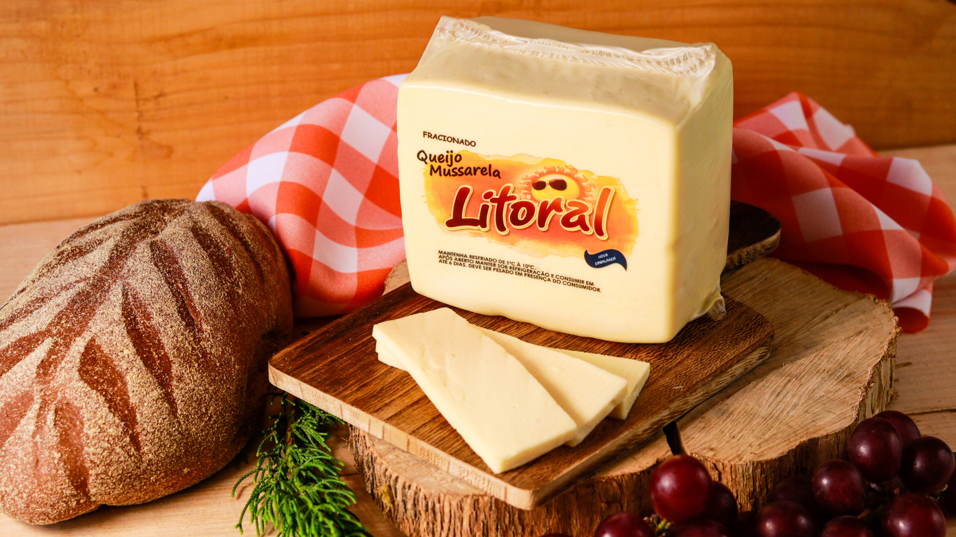 3 foto mostrando uma peça de queijo mussarela da Litoral Laticínios sob uma tábua de madeira