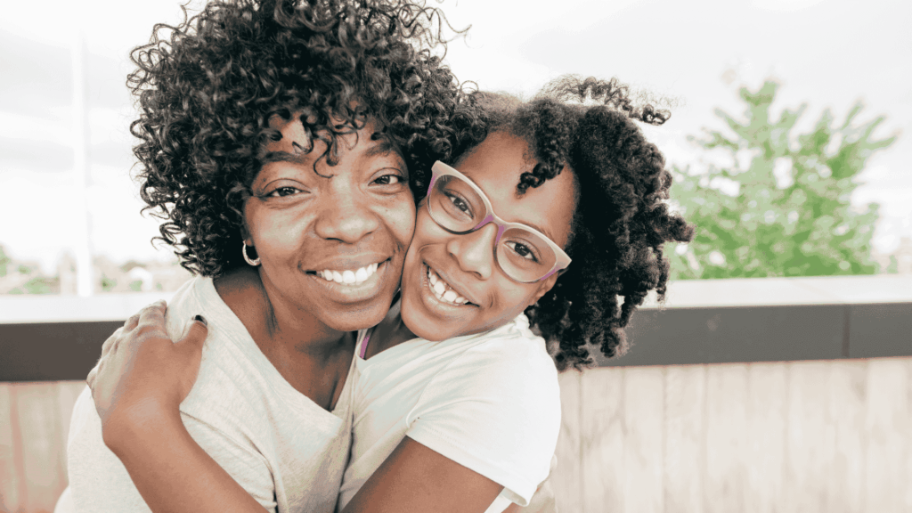 Mãe e filha sorrindo e abraçadas em momento de carinho no Dia das Mães