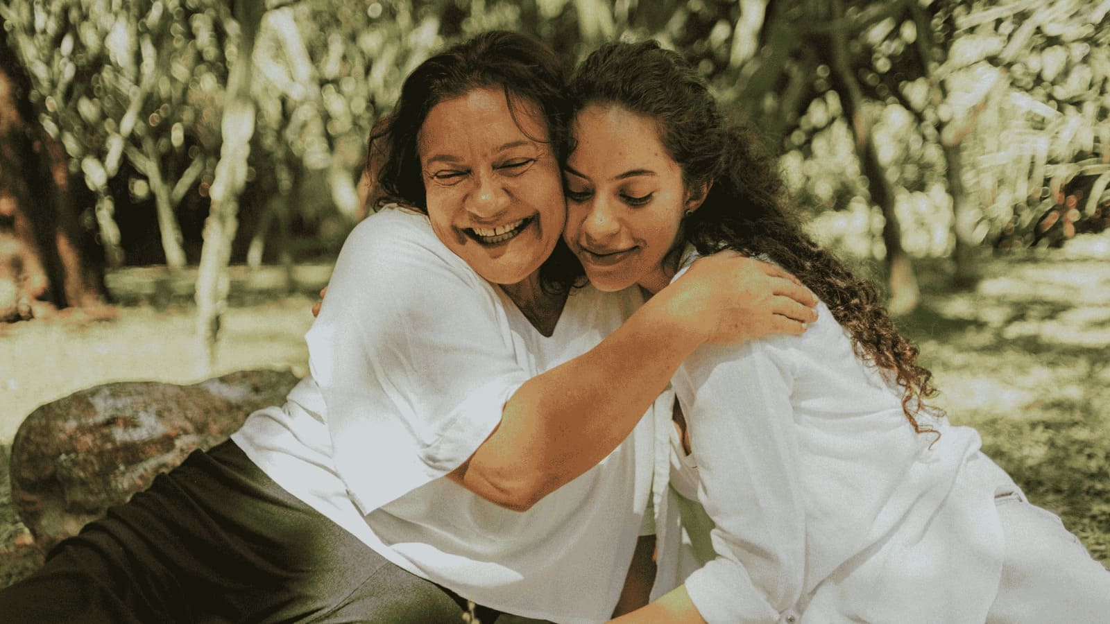 Mãe e filha abraçadas ao ar livre em momento especial de Dia das Mães