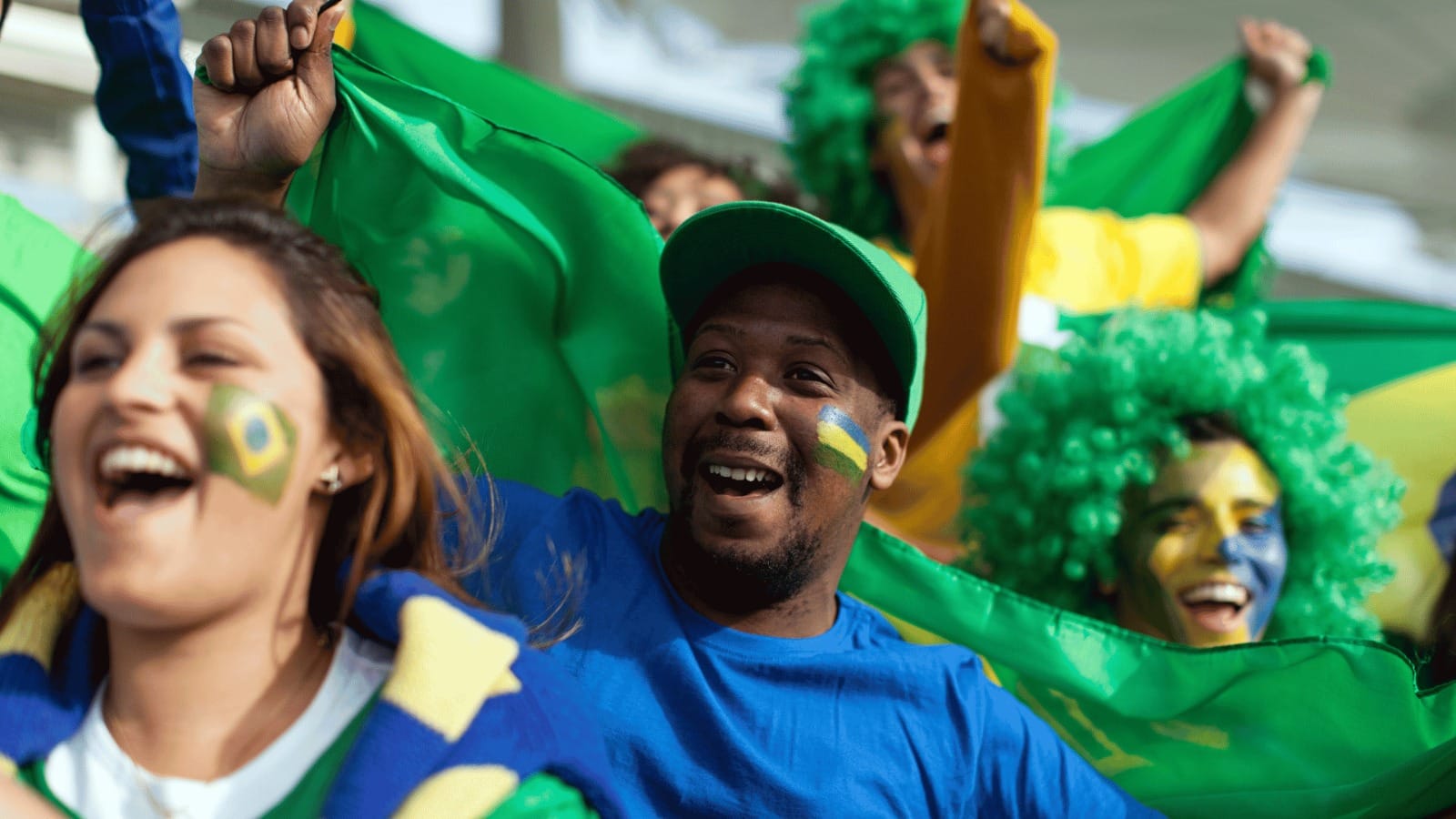 Torcedores brasileiros comemorando durante uma partida de futebol.