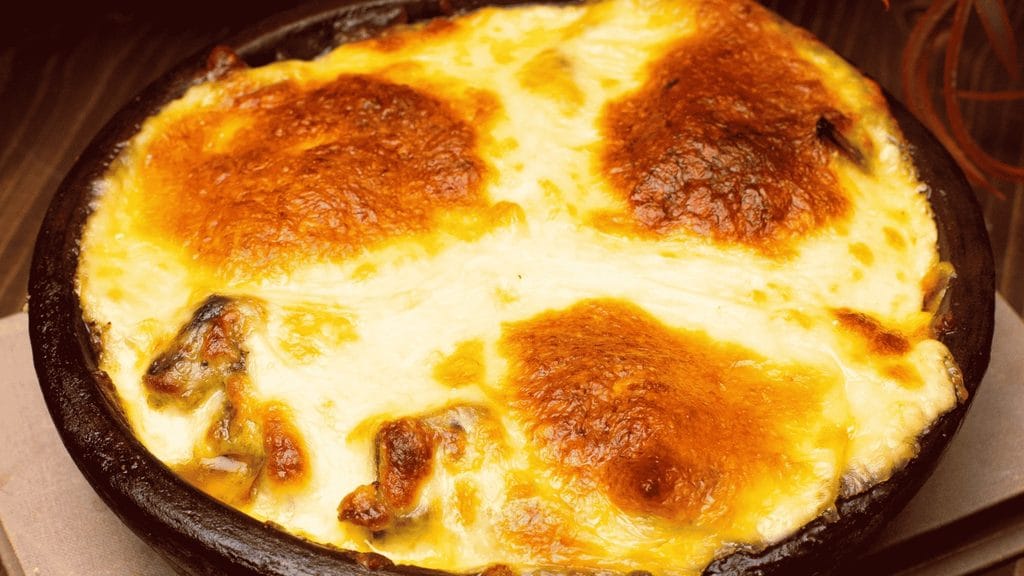 Escondidinho de frango com queijo gratinado.