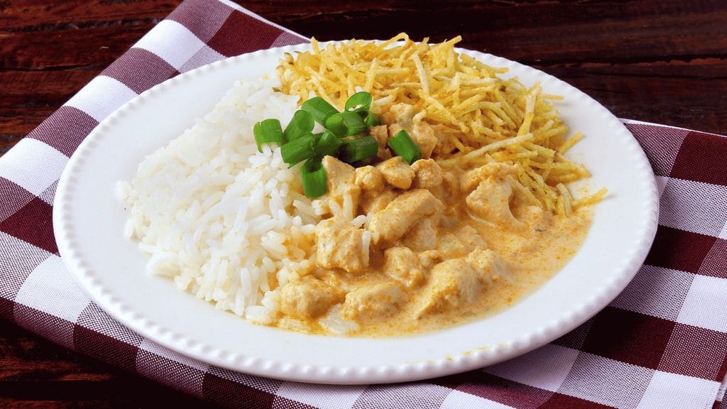 Strogonoff de frango servido com arroz branco e batata palha.
