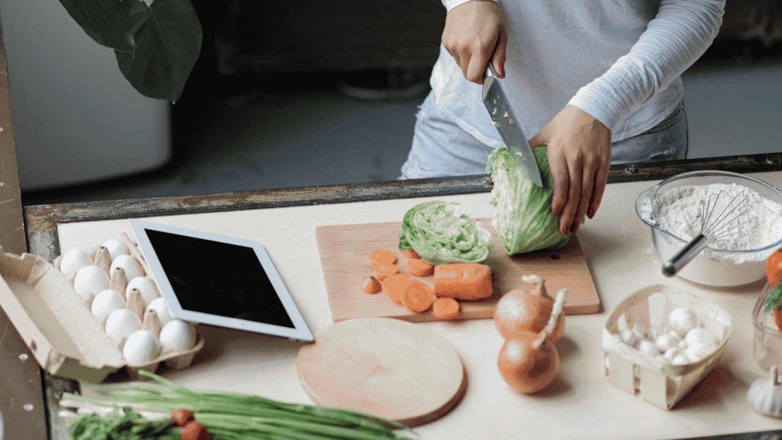 Pessoa preparando uma refeição caseira com legumes em uma cozinha.