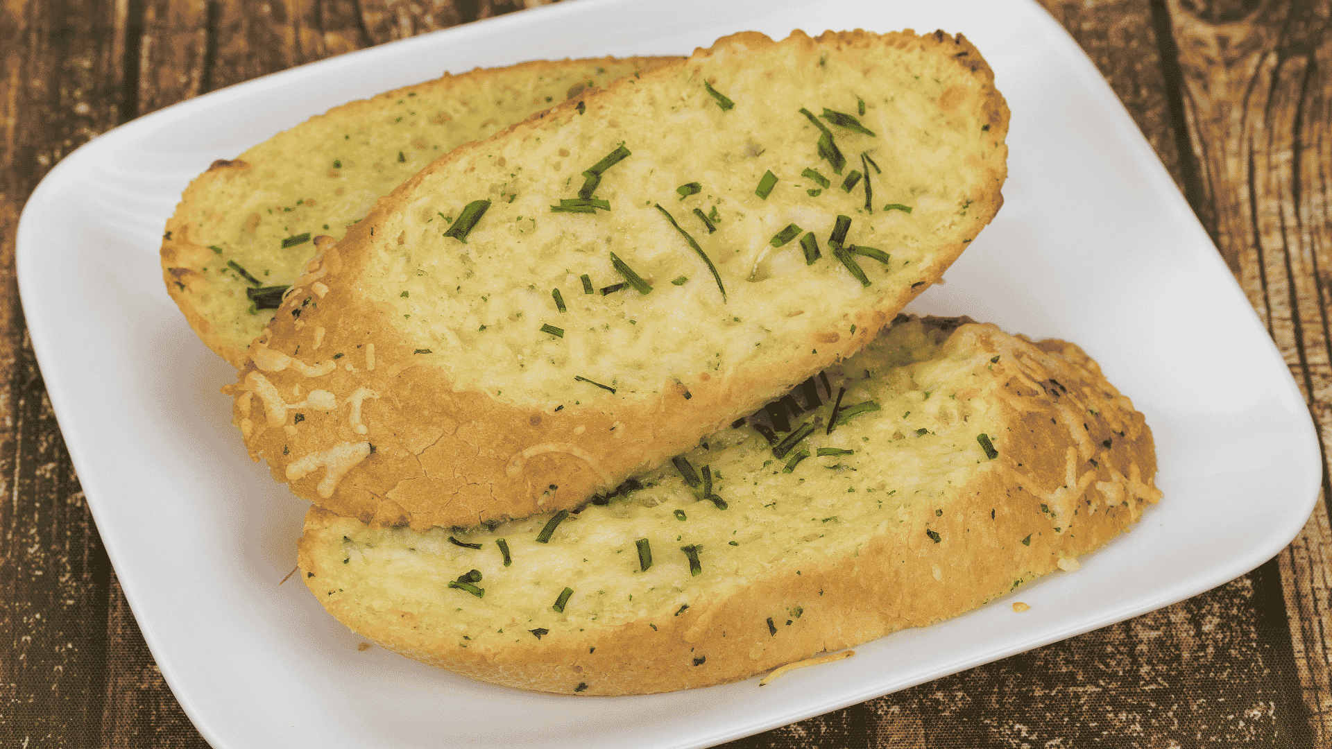 Pães de alho dourados com queijo derretido e ervas, preparados na air fryer.